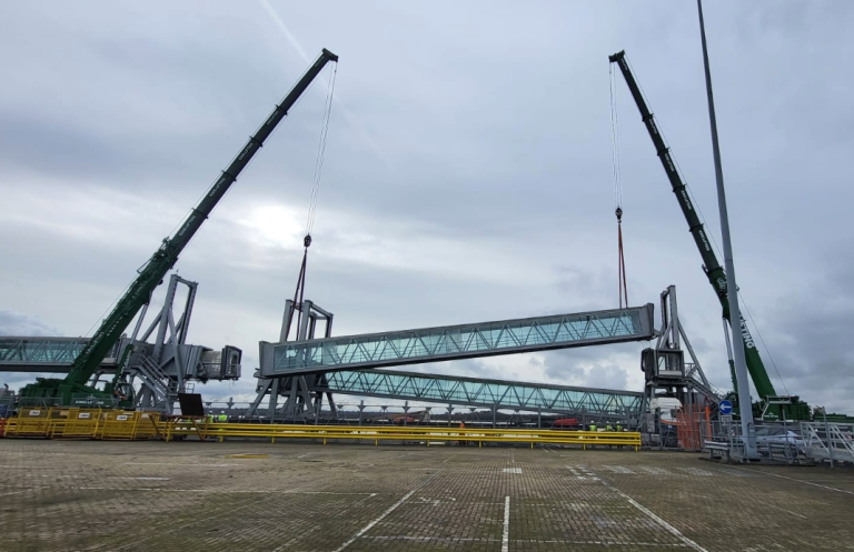 King Lifting installing an airbridge at Southampton Docks using two large green cranes on an overcast day