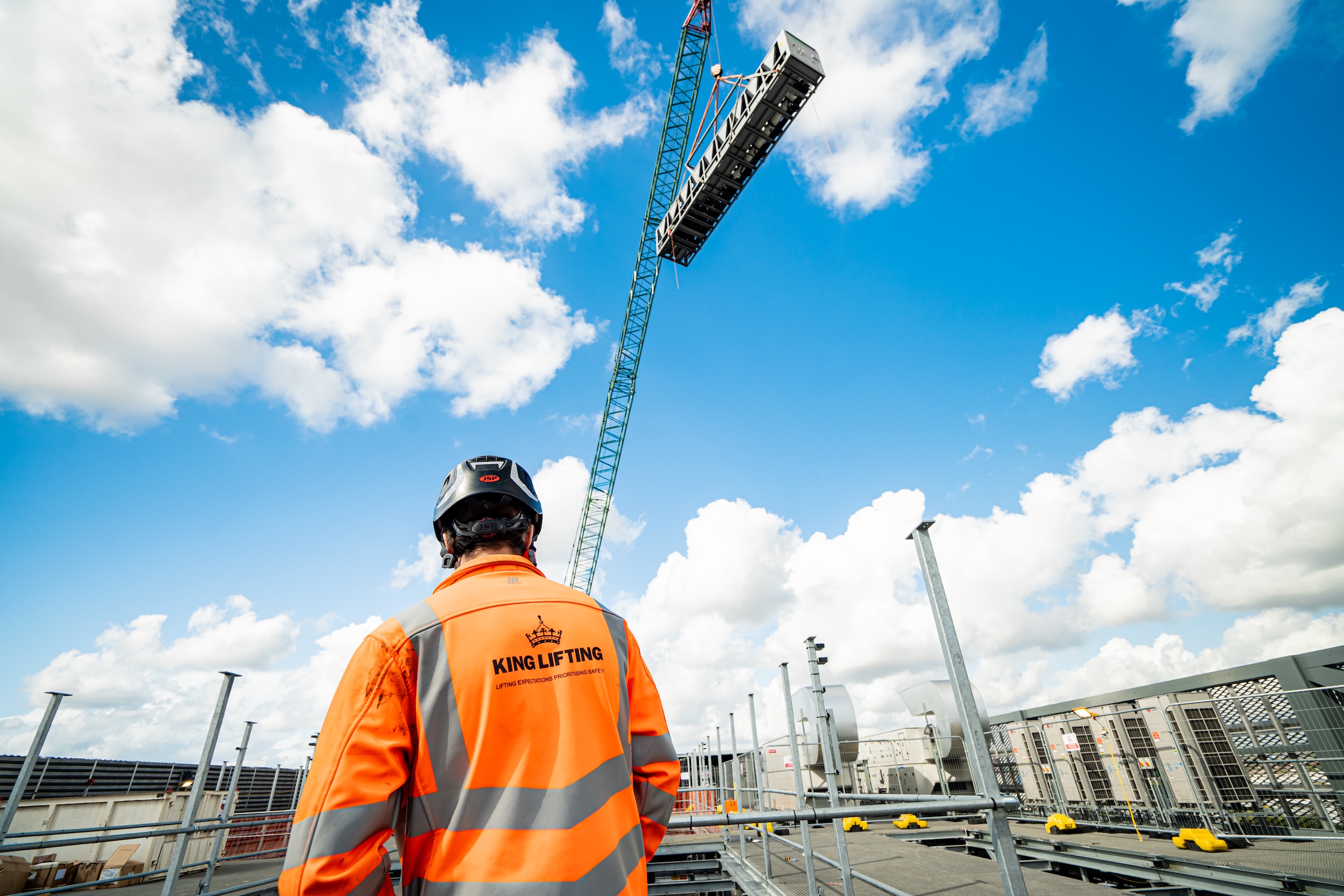 King Lifting person in orange jacket overseeing lift